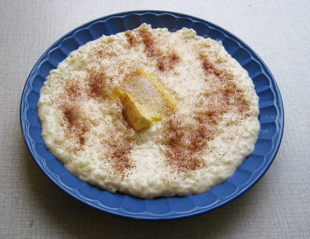 Plate of rice porridge topped with a knob of butter and cinnamon