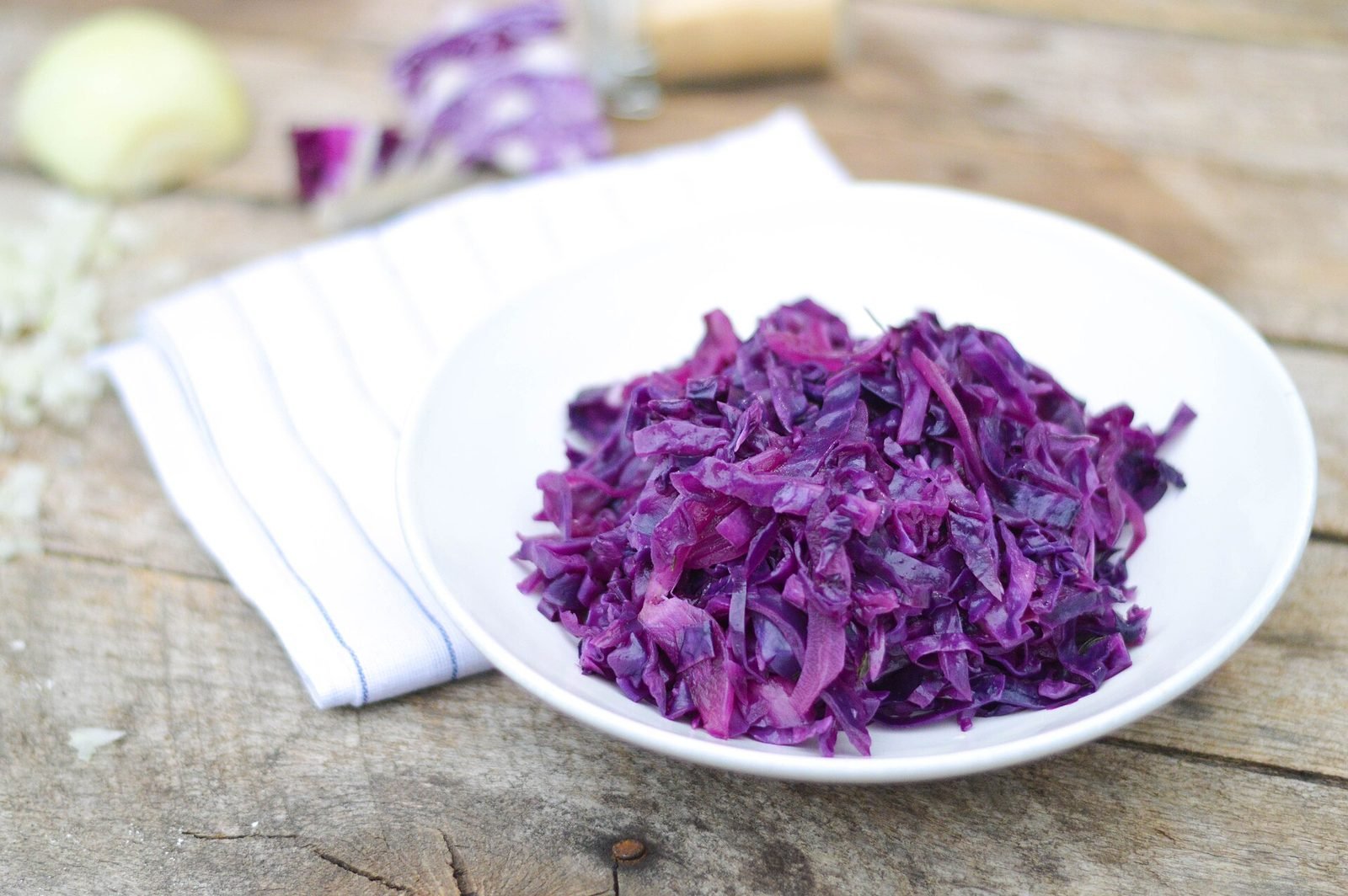 Finely shredded red cabbage in a white bowl